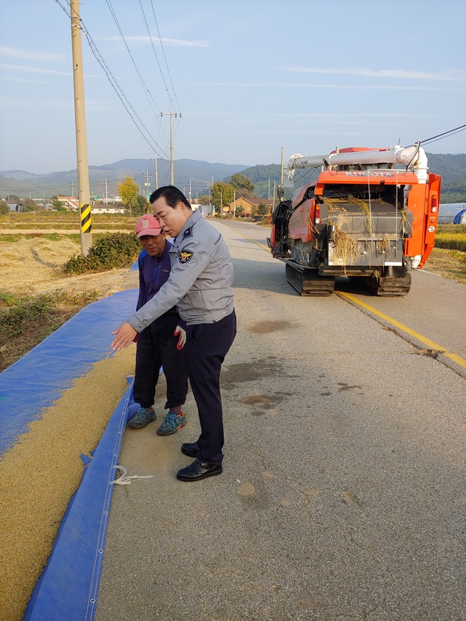 도로에 벼를 건조하는 주민들을 찾아가 교통사고예방 홍보활동에 나서고 있는 모습