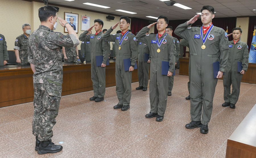 훈련을 수료한 조종사들이 비행단장에게 경례를 하는 모습