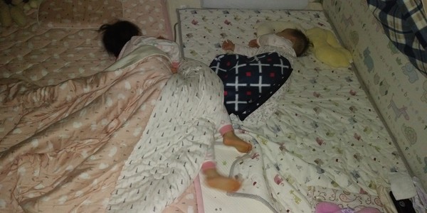 2개의 유아용 범퍼침대를 붙인 곳에서 잠을 자고 있는 다은이와 다연이
