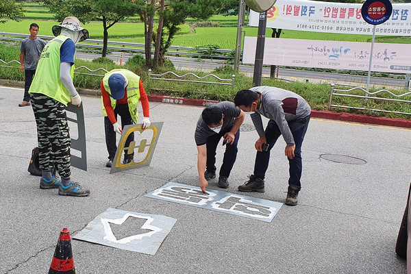 김덕제 동문1동장과 직원이 동문36통 마을안길 학동8로 앞에서 도색작업을 하는 모습