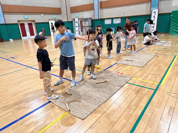 유치원 원아와 함께 활쏘기를 하고 있는 초등학교 1학년 학생